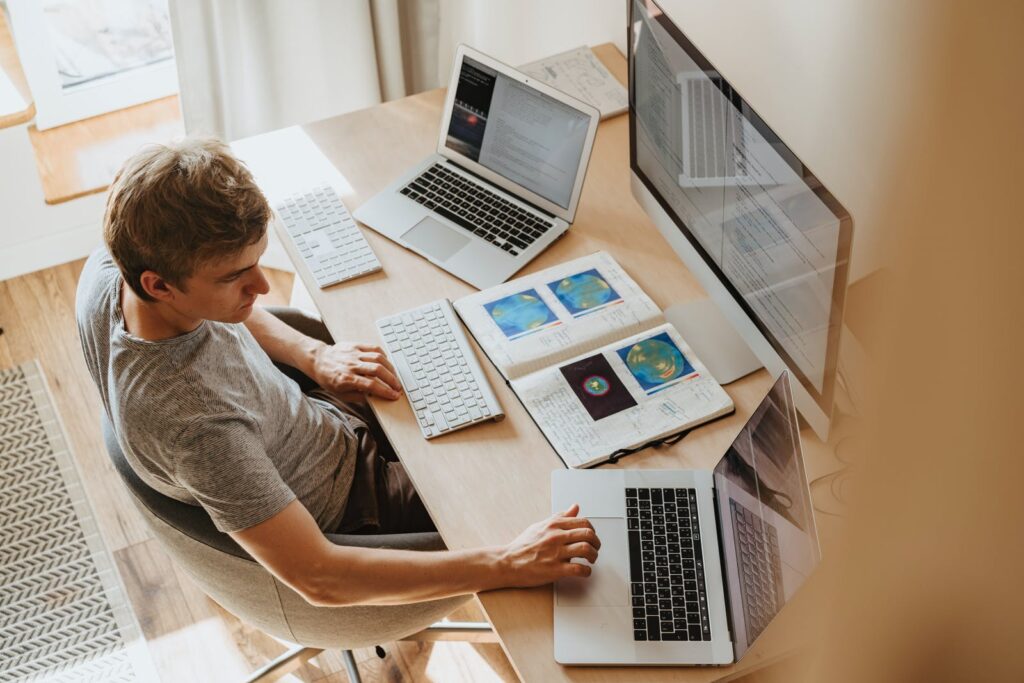 Man sitting in front of a computer, looking at something. Depiction of File Management Software
