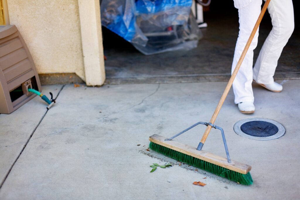 Preparing for Pressure Washing - sweeping a driveway