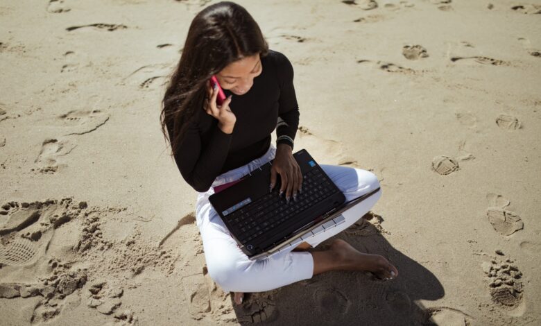 woman with laptop on beach