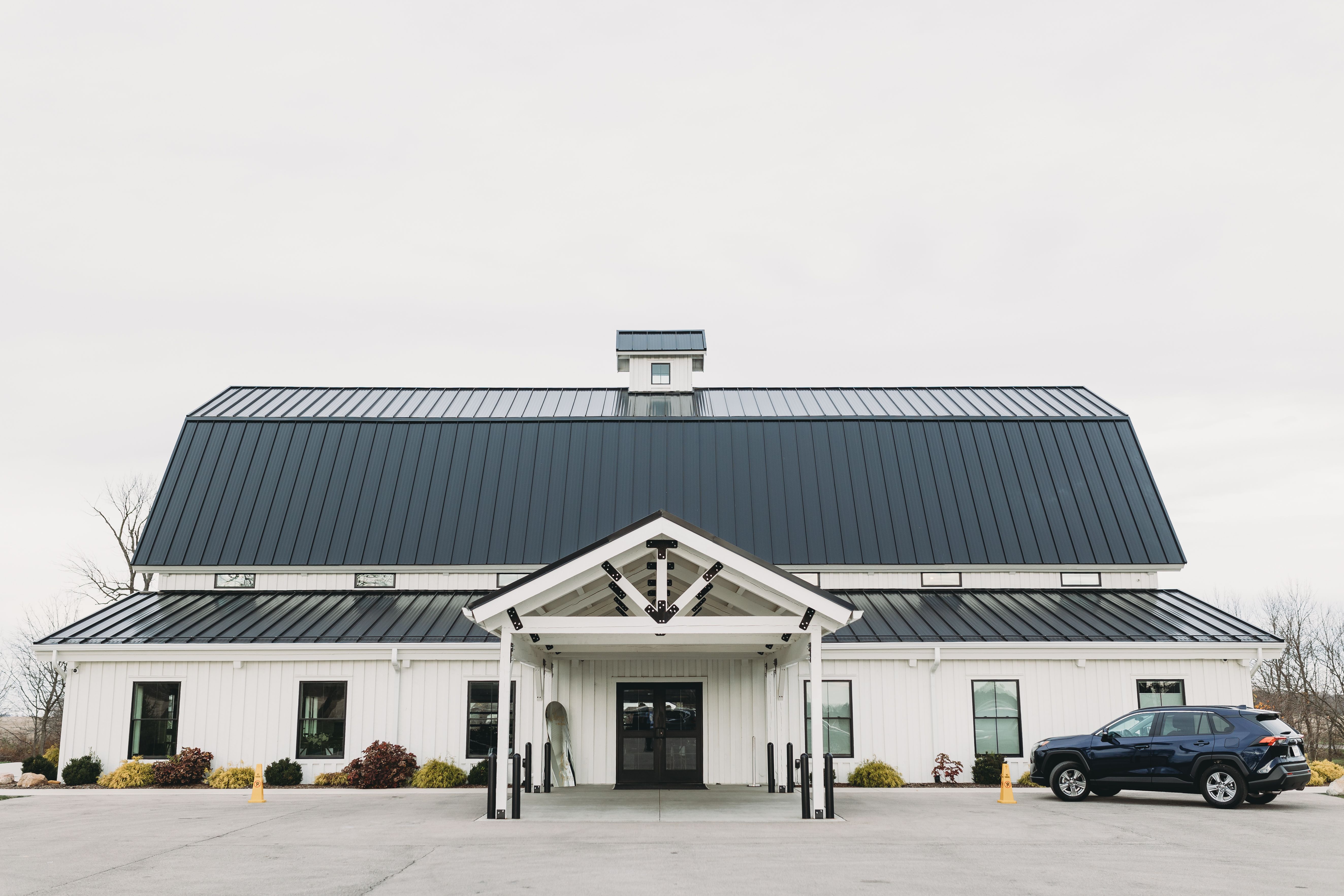 White barn-style event venue with a broad roof, representing a property to prepare before a gathering.